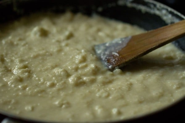 stirring milk cake batter with wooden spoon