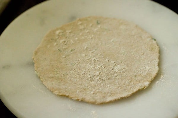rolling lauki paratha and dusting with flour