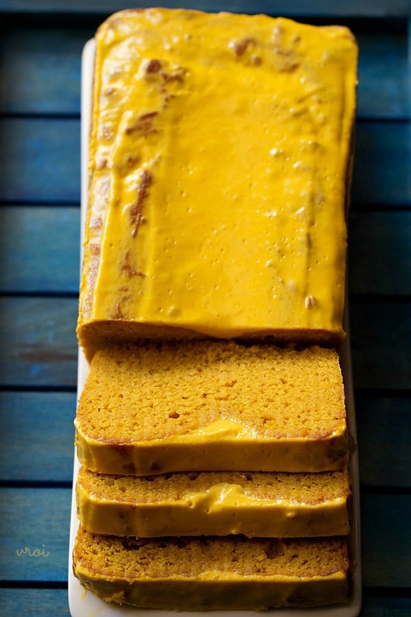 eggless mango cake with mango mousse icing on a rectangular serving platter