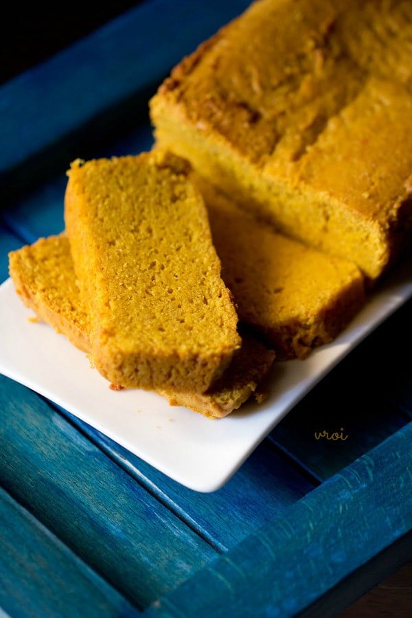 mango cake slices on a white rectangular plate on a blue table