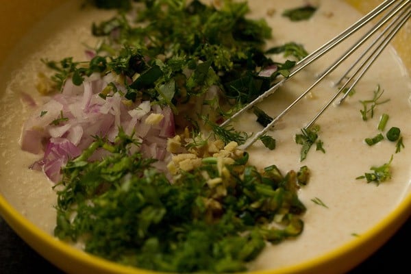 onions , ginger, green chilies, coriander leaves and curry leaves in oats dosa batter