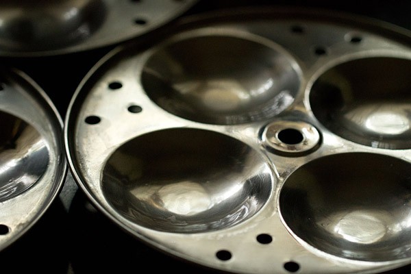 Closeup shot of idli moulds greased with oil.