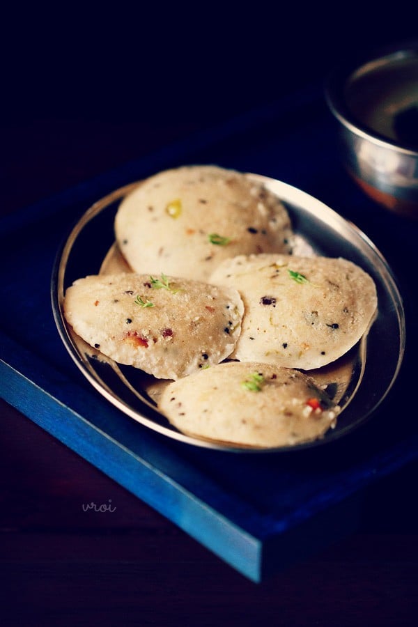 Top shot of four round oats idli arranged on silver plate.