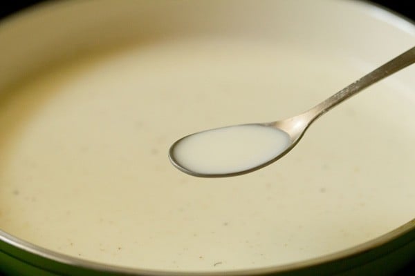 adding prepared cornstarch paste to hot milk in pan. 