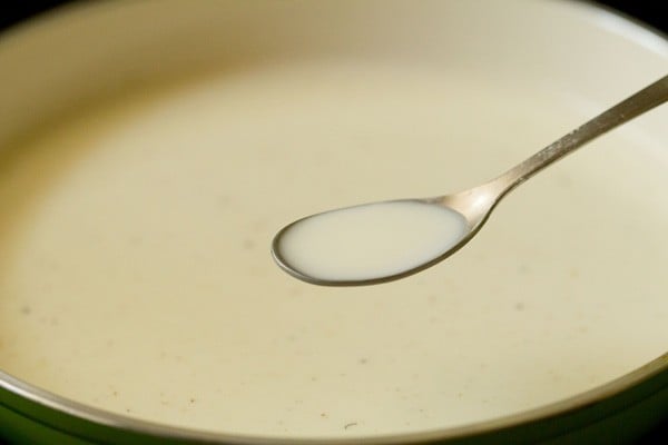 adding prepared cornstarch paste to hot milk in pan.