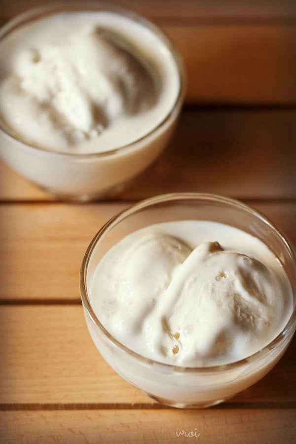 vanilla ice cream scoops served in 2 glass bowls.