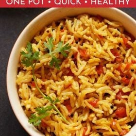 Tomato Rice with a coriander leaf sprig served in a cream bowl on a black board