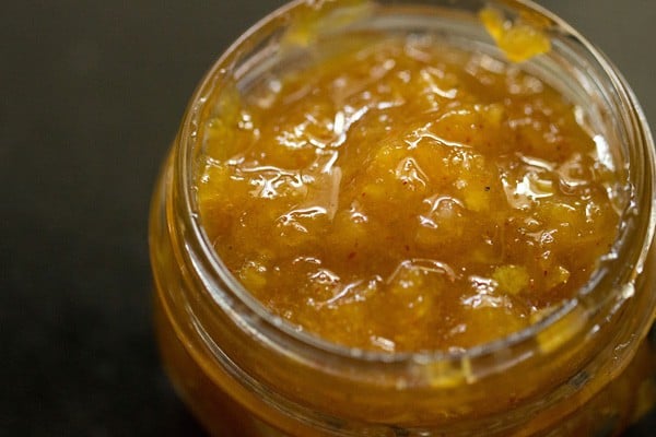 aam chunda spooned in a glass jar. 