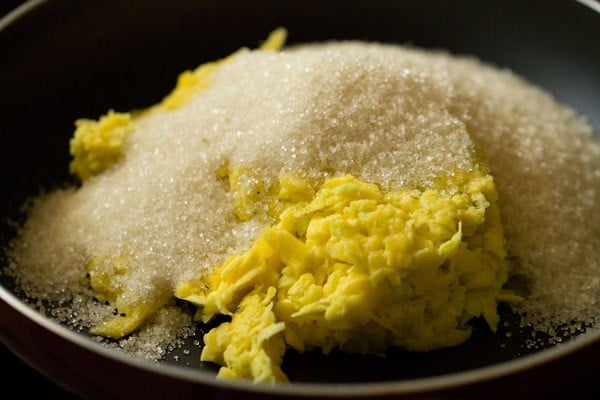 grated mangoes, sugar and salt added in a pan. 