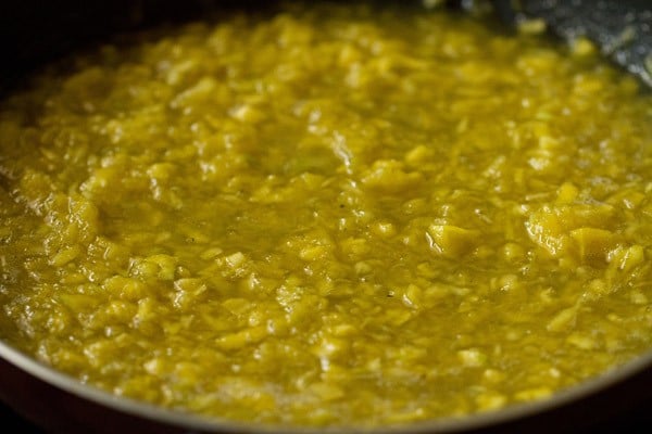 cooking the mango mixture in the pan. 