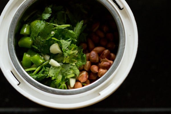 roasted peanuts, chopped green chili, chopped garlic and chopped coriander leaves added to a grinder jar for making the stuffing for bharli bhendi. 