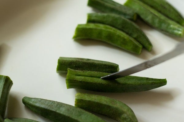 slitting okra pieces without crown and base tip. 