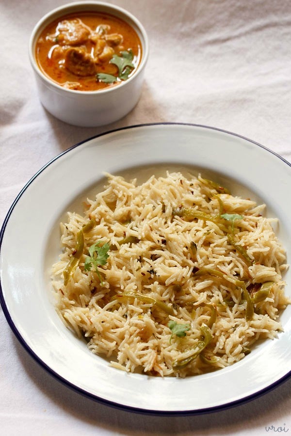 capsicum pulao in a plate served with curry in a bowl