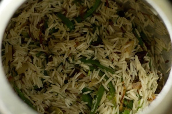 rice grains mixed with capsicum mixture. 