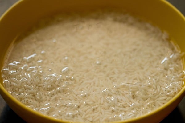 rice soaking in water in yellow bowl. 