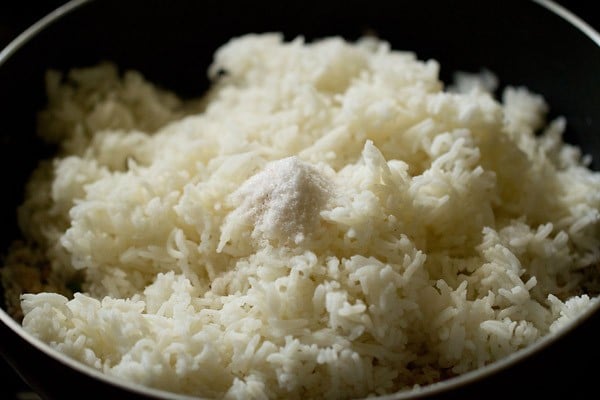 cooked rice and salt added to the pan. 