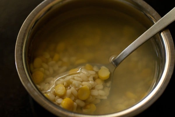 soaked lentils in a spoon in water. 