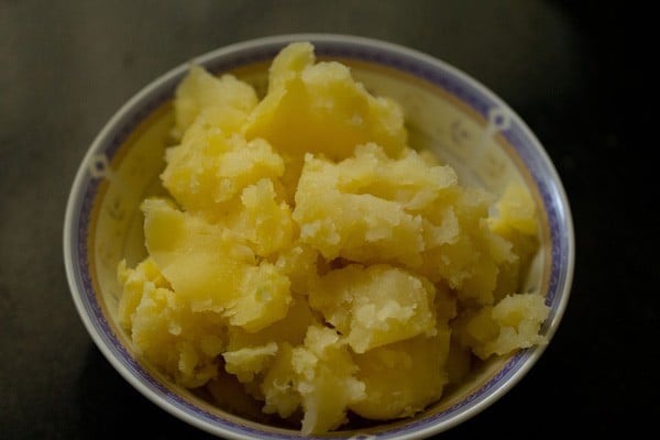 boiled, peeled and crumbled potatoes in a bowl to make dahi aloo.