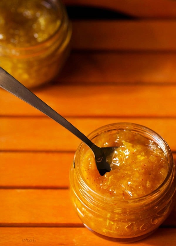 aam chunda in a glass jar with a spoon kept in it. 