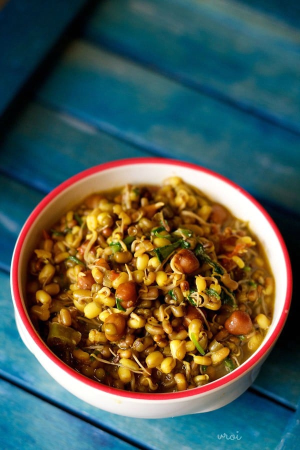 sprouts curry served in a red-rimmed ceramic bowl. 