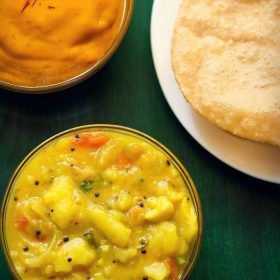 poori masala and aamras, served in two glass bowls with poori on a white plate with text layovers.