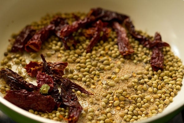 roasting the spices in a pan for aloo kurma. 