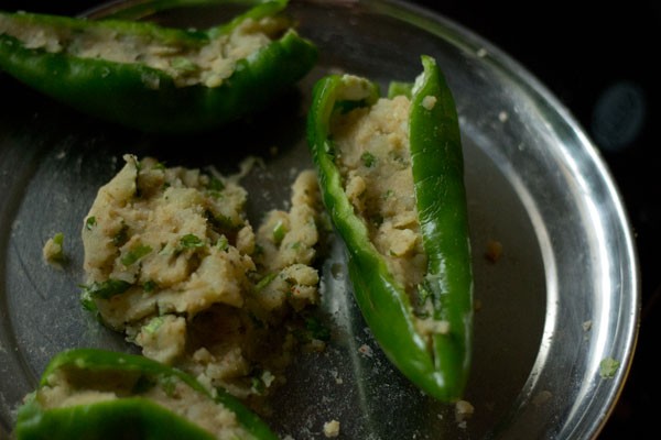 stuffing green chilies with the prepared potato mixture. 