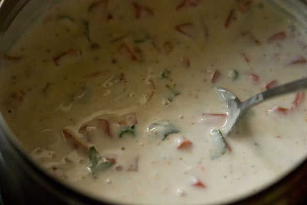 mixing ingredients to make tomato raita