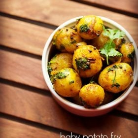 baby potato fry garnished with a coriander sprig and served in a white bowl with text layovers.