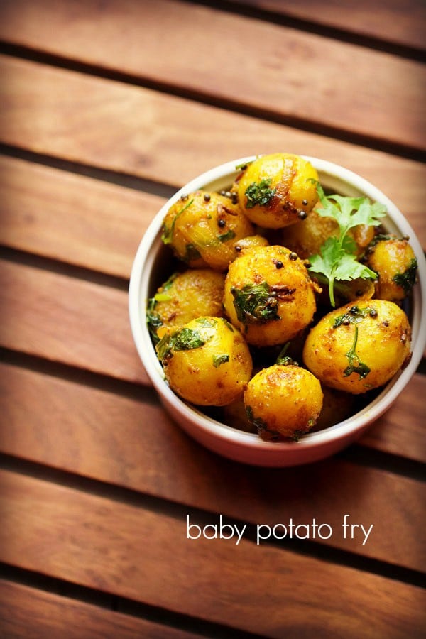 baby potato fry garnished with a coriander sprig and served in a white bowl with text layovers.