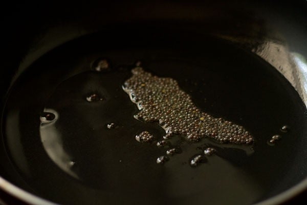 mustard seeds crackling in hot sesame oil in pan. 