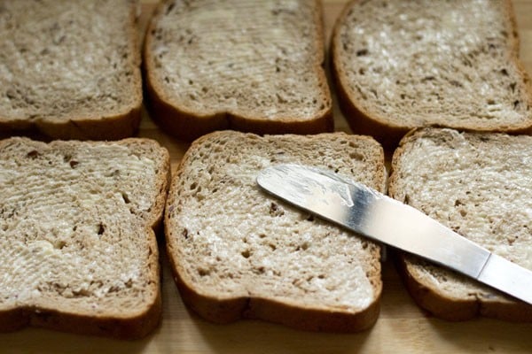 spreading butter on bread slices. 