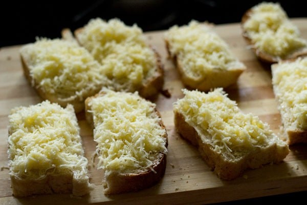 buttered bread slice halves topped with grated cheese. 