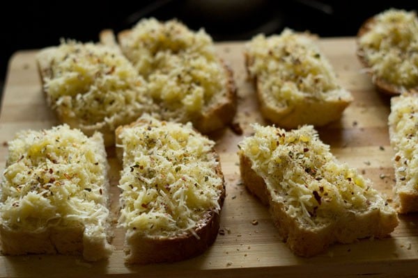 herbs and spices sprinkled on the cheese topped bread slice halves. 