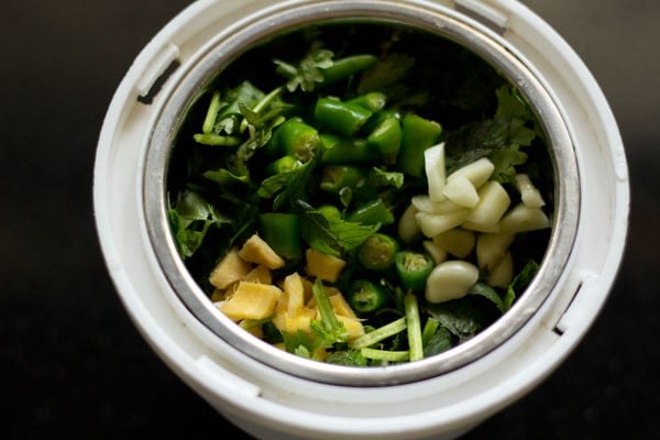 Ginger, garlic and herbs in a grinder.