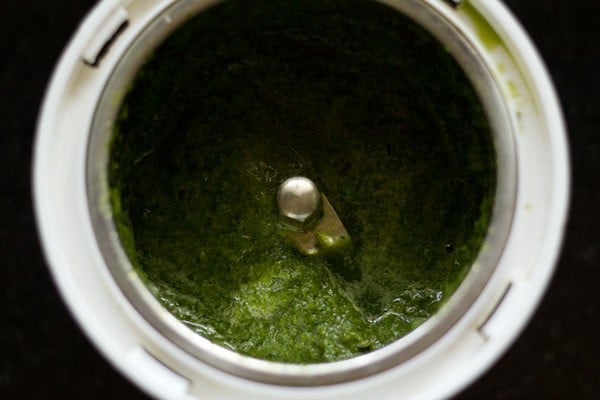 Green ginger and herb paste in grinder.