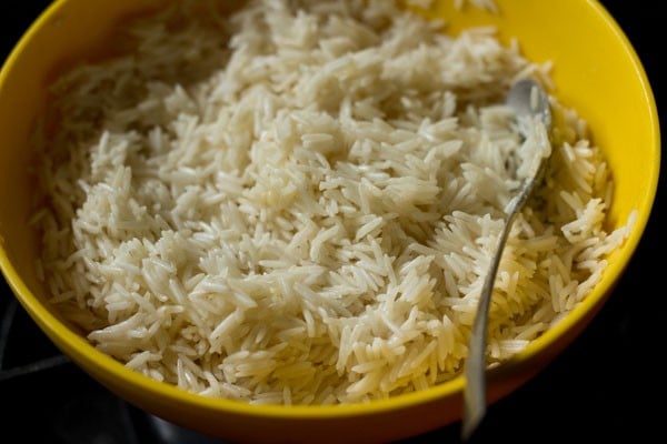 Rice in yellow bowl with spoon.