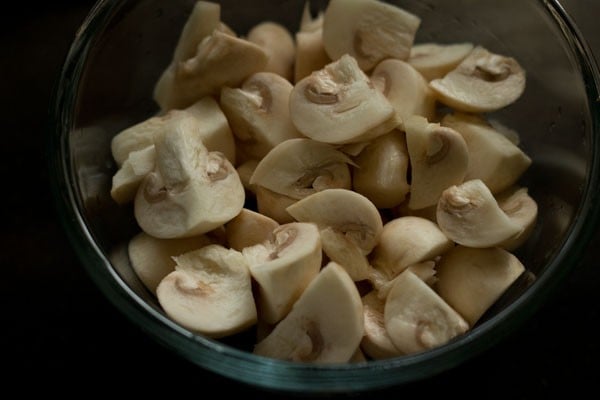 Chopped mushrooms in glass mixing bowl.