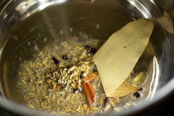 tej patta and spices in oil in pan