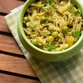 coriander rice garnished with coriander leaves and served in a green bowl.
