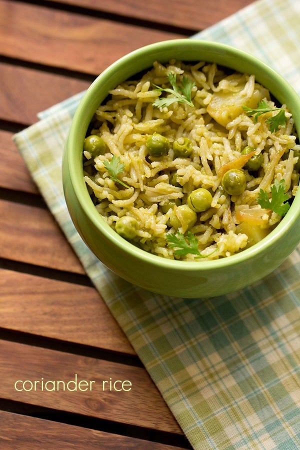 coriander rice garnished with coriander leaves and served in a green bowl.