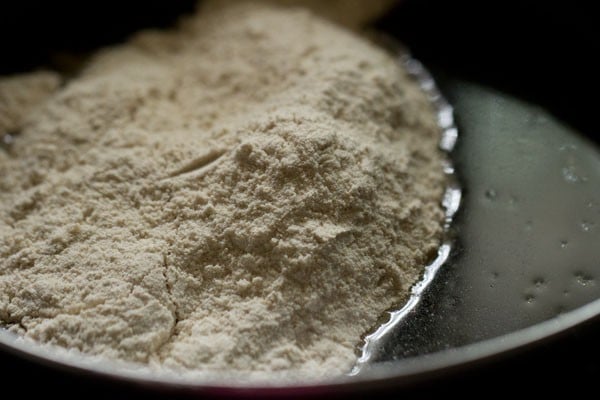 Dry ingredients added to liquid mixture in bowl for muffin recipe.