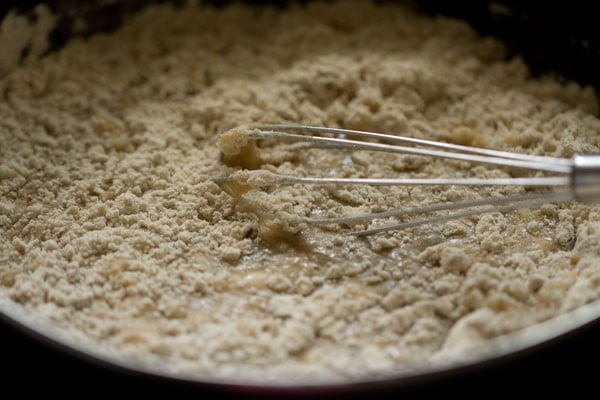 Whisk mixing chocolate chip muffins batter in bowl.