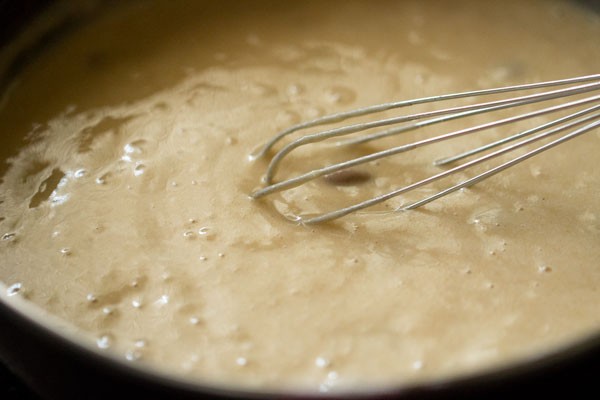 Whisk mixing smooth muffin batter in bowl.