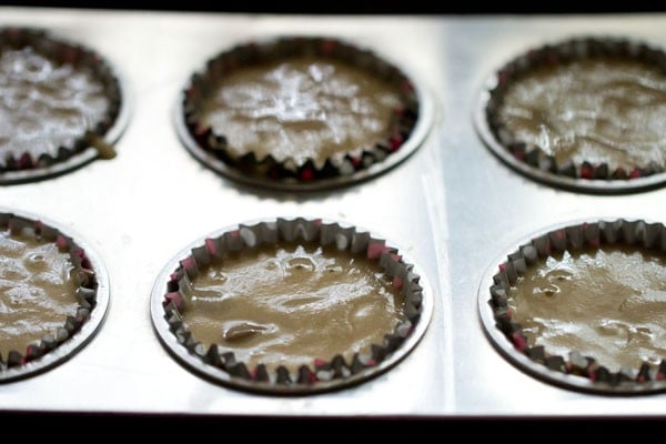 Chocolate chip muffins batter poured into muffin tin for baking.
