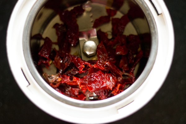 deseeded and chopped soaked dried red chilies added to a grinder jar. 