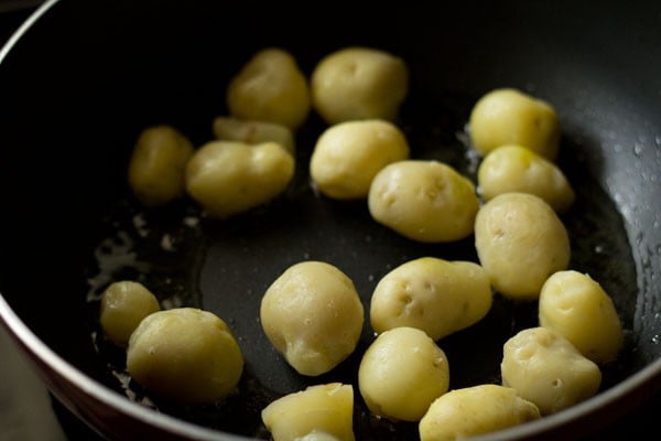 baby potatoes added to hot oil in pan. 