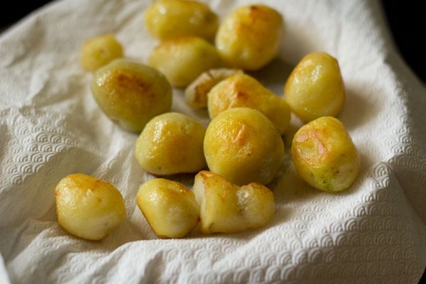 pan fried potatoes placed on kitchen paper towel. 