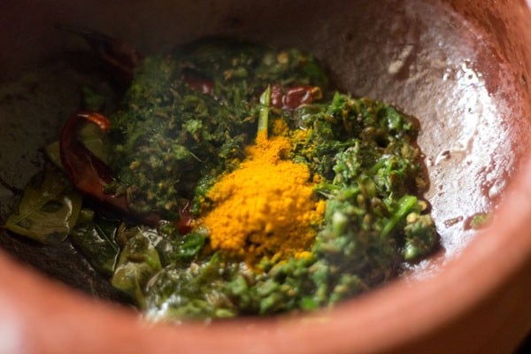 ground paste, asafoetida and turmeric powder added to the pan. 