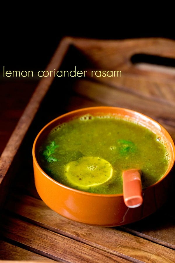 lemon rasam served in a brown colored bowl with a spoon inside and text layover.